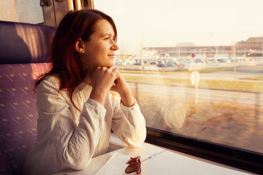 A woman looking out of a window on a train