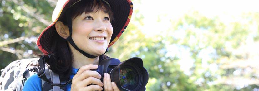 A woman smiling and holding a camera
