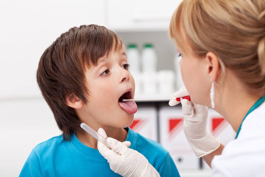 Doctor examining child's throat