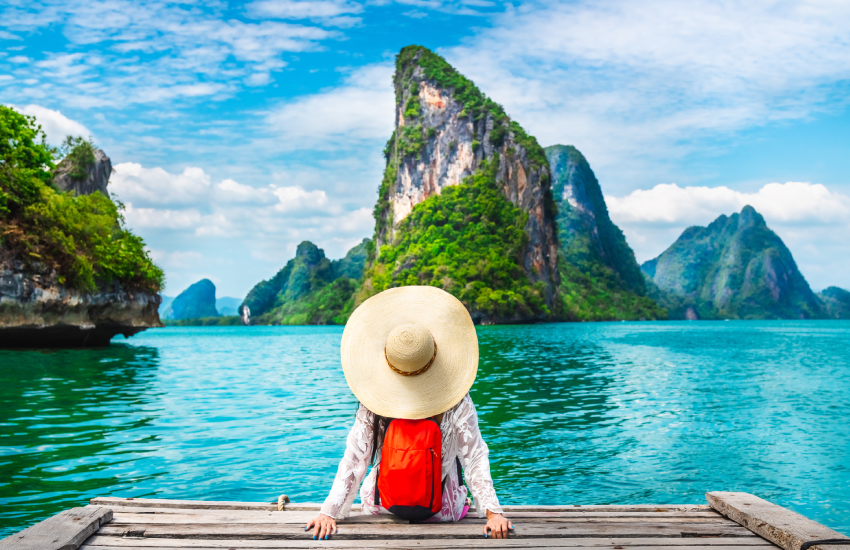 Woman with a hat on the water's edge admiring the landscape