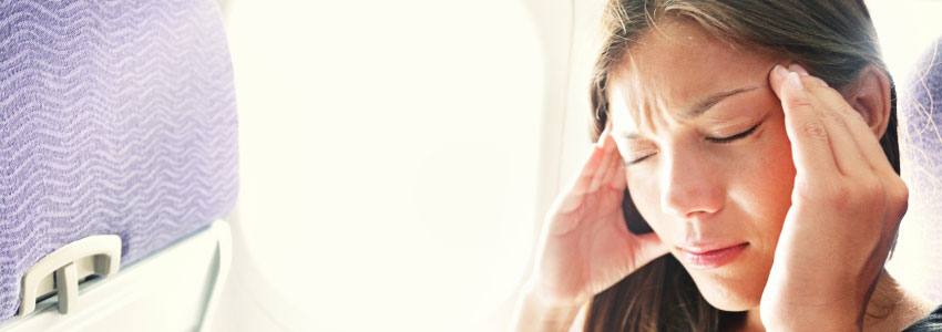 A woman has a headache while in an airplane 