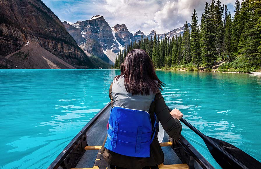 Tourist canoeing on Moraine Lake in Banff National Park, Canadian Rockies, Alberta, Canada. 