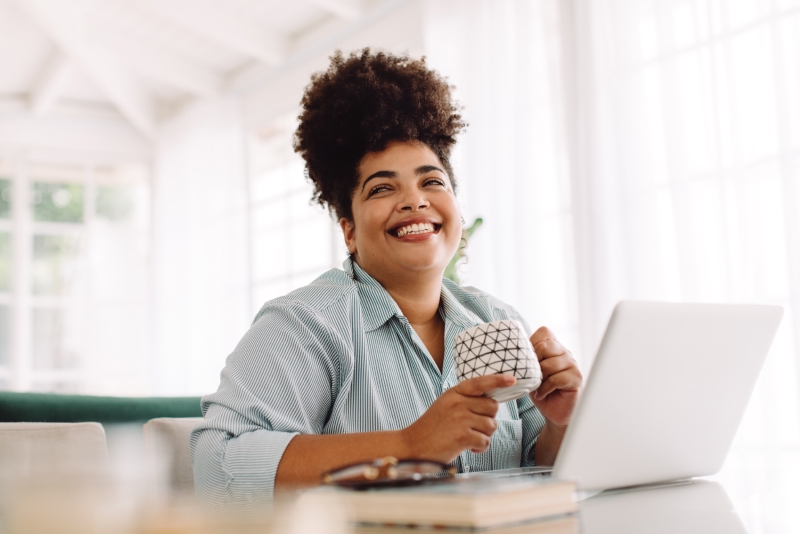 woman smiling front of desk with laptop