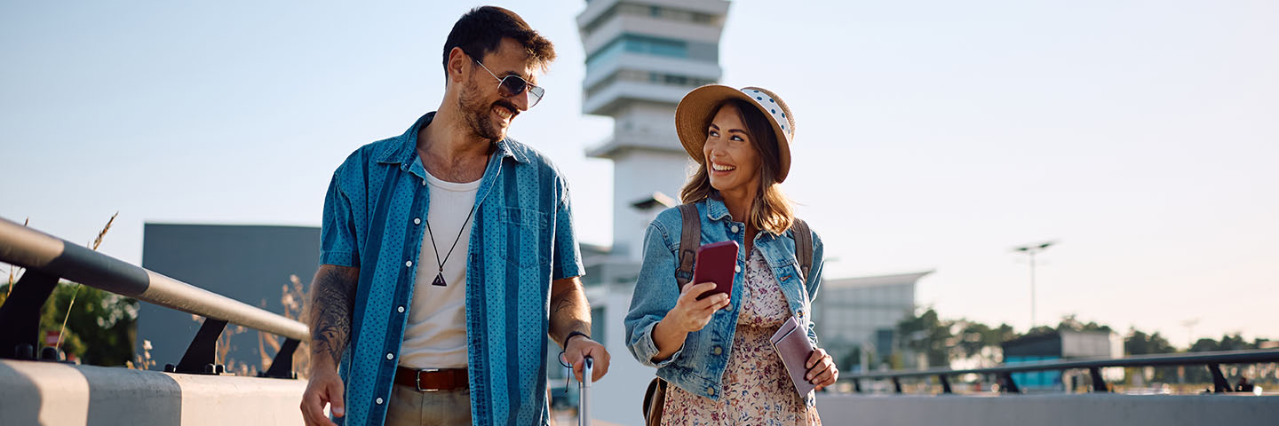 Travellers with their baggage and travel documents near an airport. 