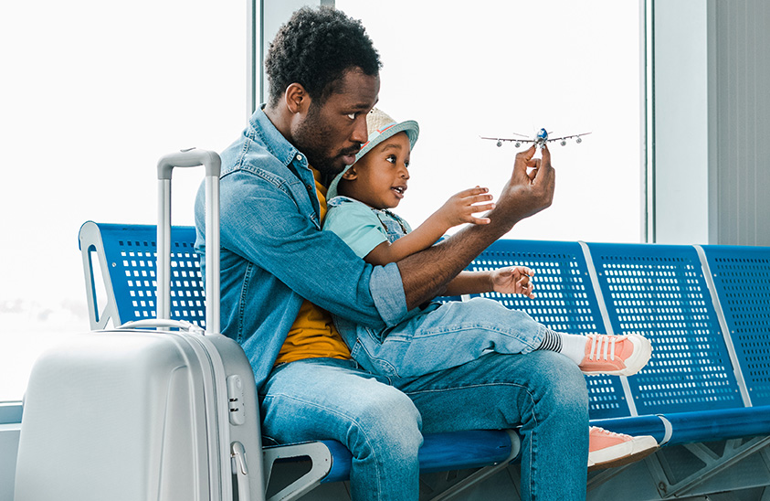 Father and son waiting for their plane, sitting at the airport.