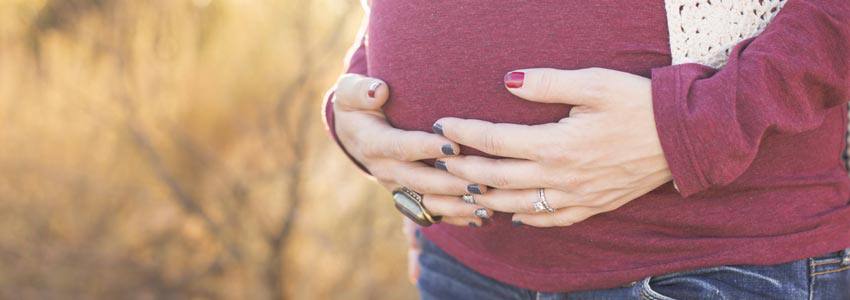 Pregnant women holding her belly with her two hands