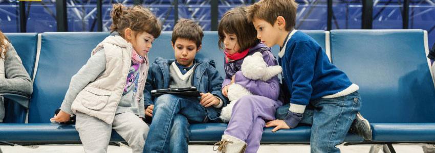 Three children sitting and watching an iPad 