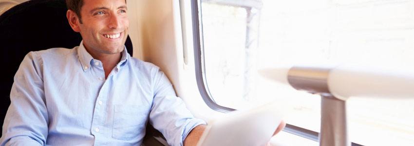 A man on his computer while riding a train