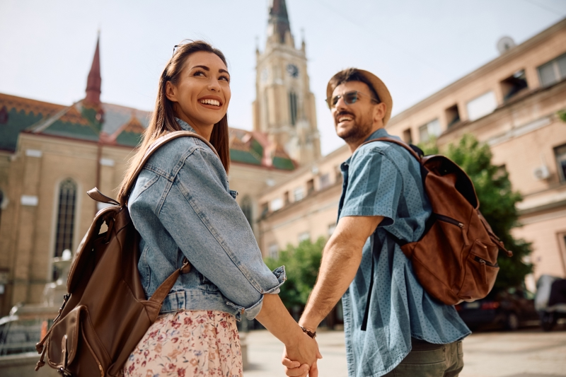 Young couple holding hands while strolling through a European city.