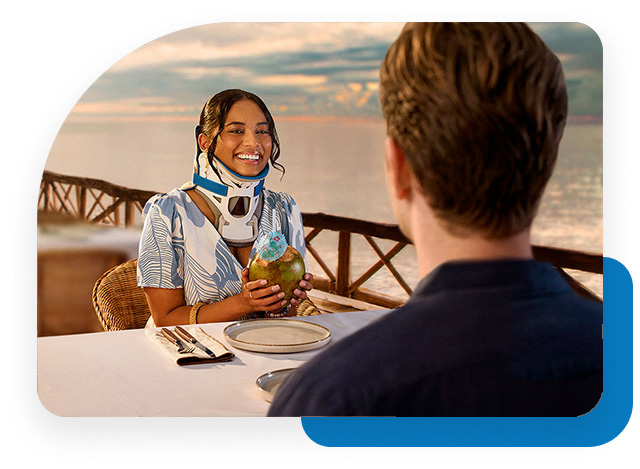 Smiling young woman wearing a neck brace in a seaside hotel restaurant.