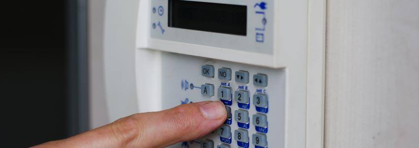 A person entering the code to an alarm in their house