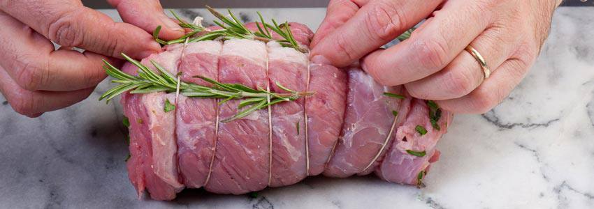 A piece of meat tied with rosemary leaves